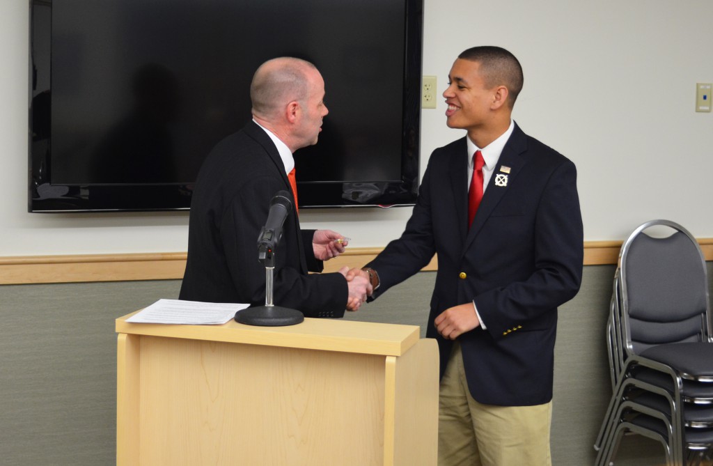 University of Maine student Lee Jackson shakes Old Town city council president David Mahan's hand as he is given the key to the city of Old Town during a city council meeting at city hall on April 4. Photo by Ian Ligget, staff.